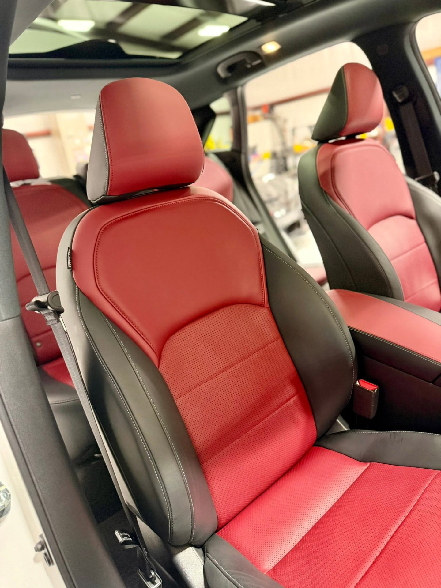 Red and black leather front seat in an Infiniti QX50S after a full interior detail