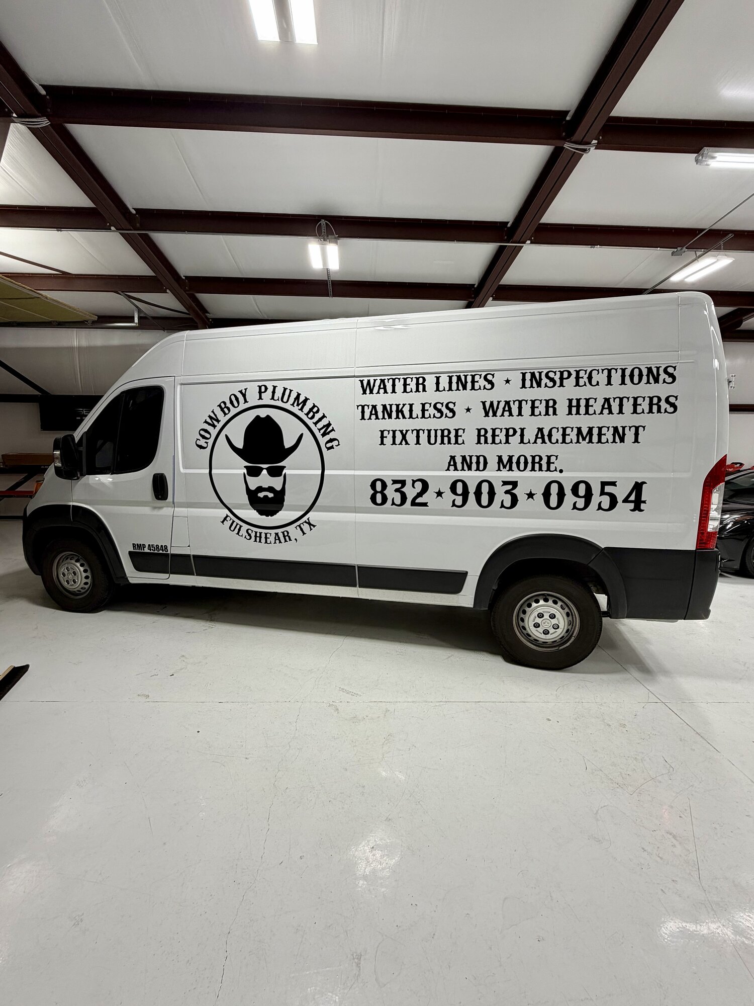 White Cowboy Plumbing Ram ProMaster van with commercial graphics